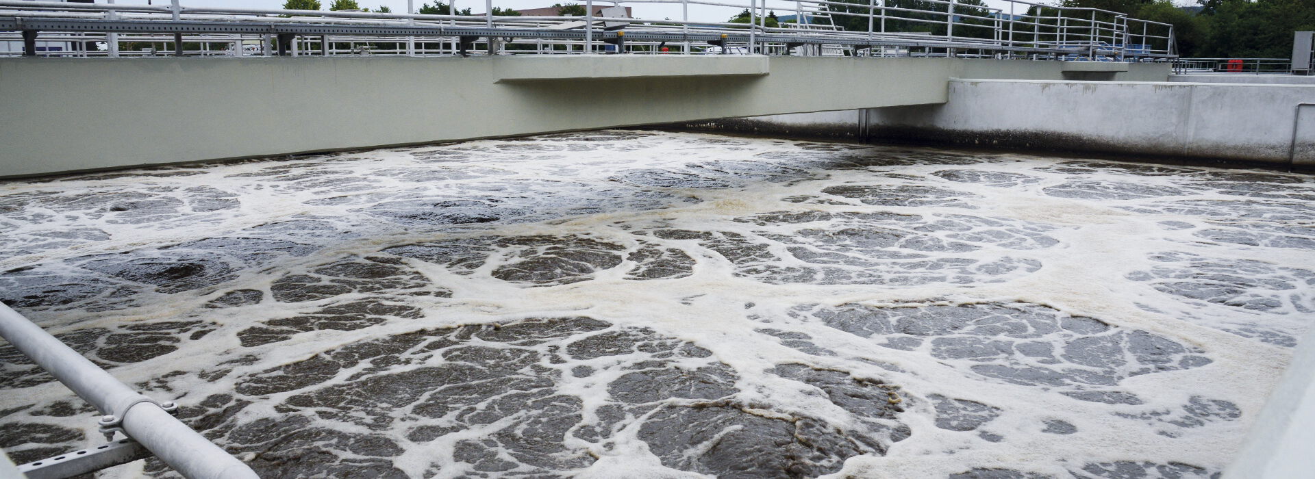 Foto: Das Belebungsbecken - ein längliches Betonbecken, über eine Betonbrücke führt.